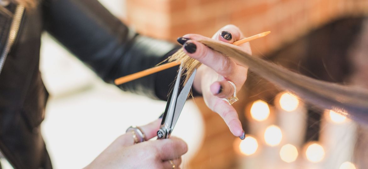 woman-stylist-cuts-hair-at-salon